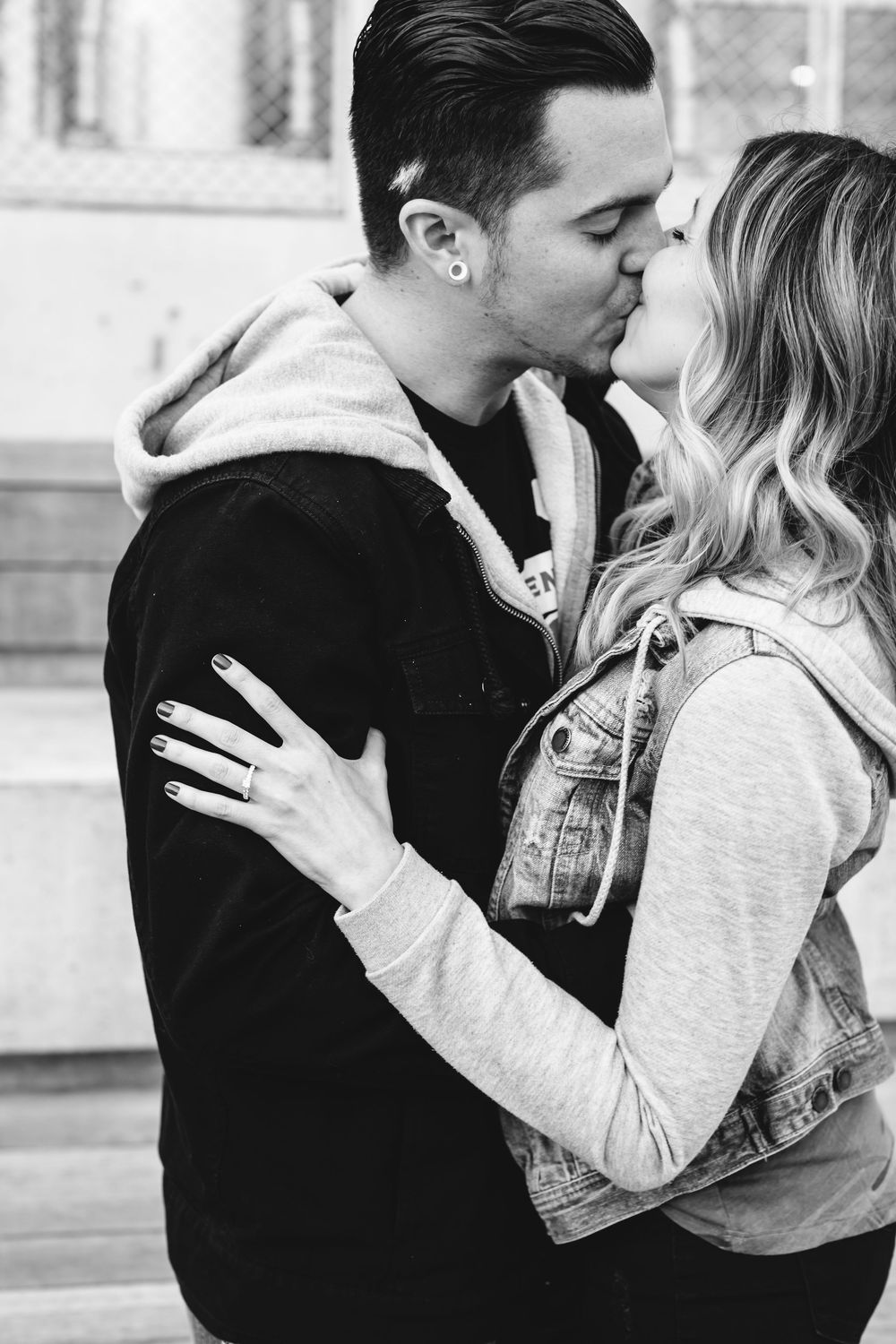 Black and white photo series capturing intimate engagement moments against urban backdrop.