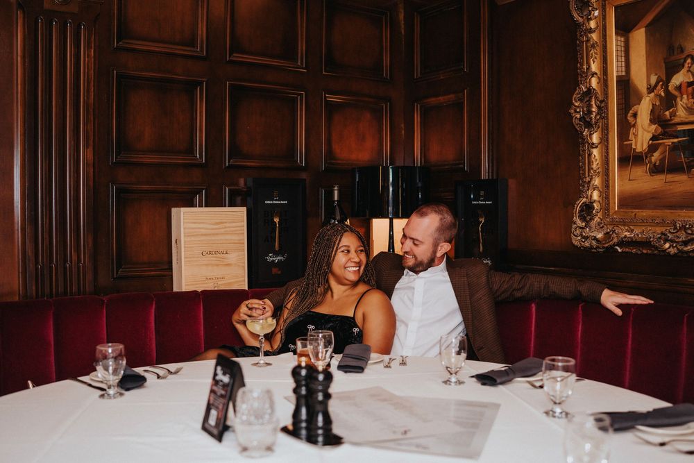 Elegant banquet hall interior with dark wood paneling and white tablecloths set for formal dining.