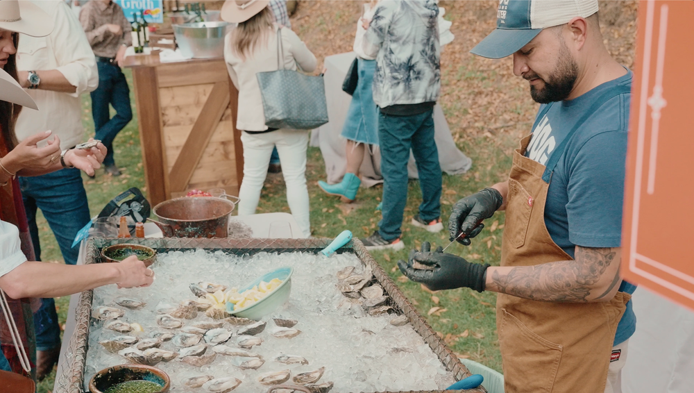 A group of people gathered outdoors for a pottery workshop, working with clay and ceramic materials.