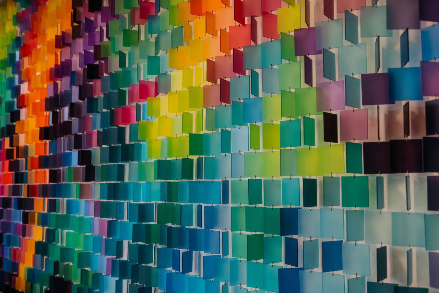 Vibrant multicolored abstract wall art made of rectangular shapes arranged in vertical stripes creates a dynamic pattern.