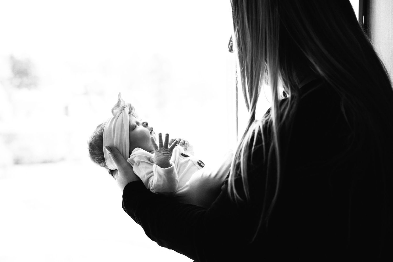 A silhouetted figure with long hair is shown in a dramatic black and white profile against a light background.