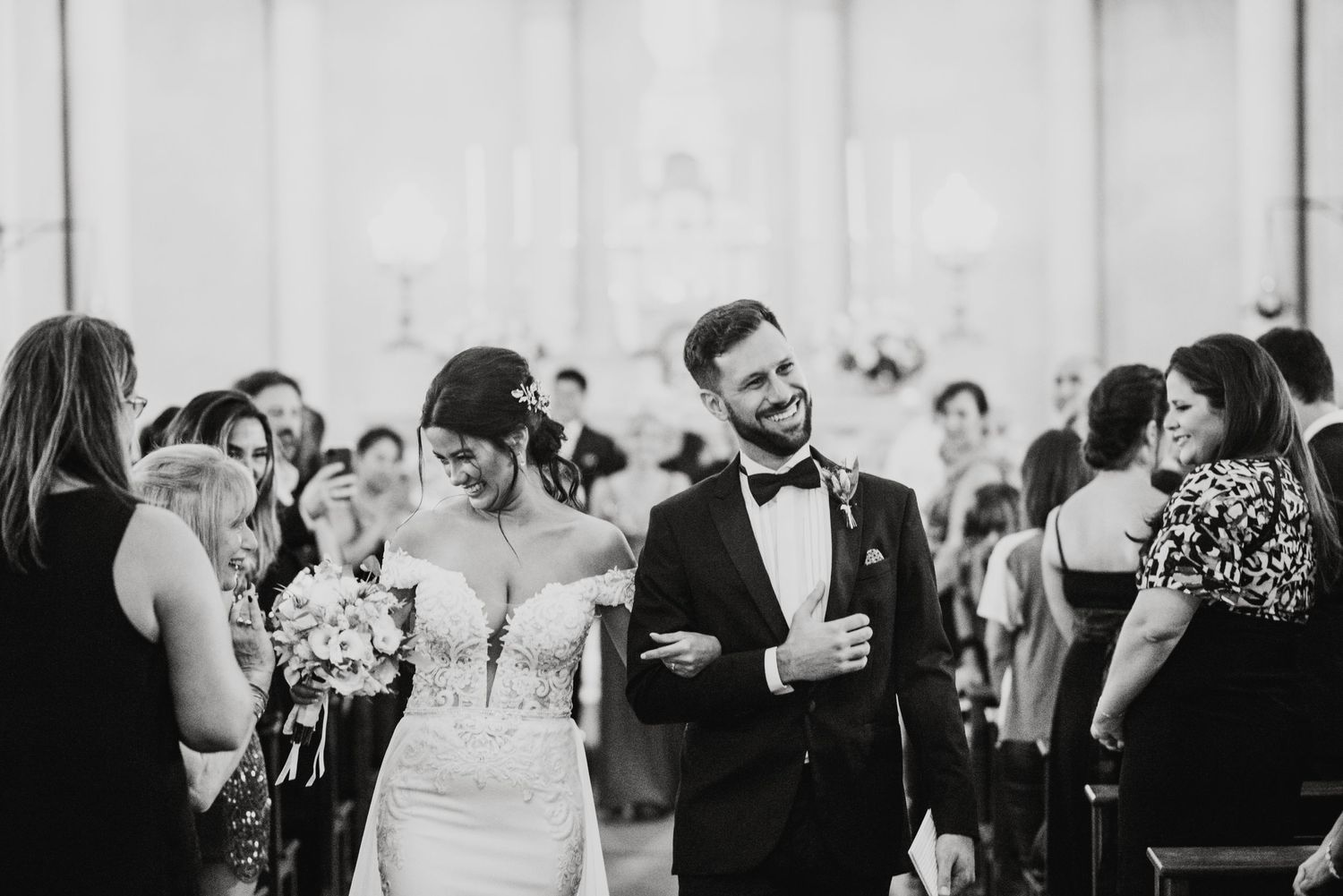 Wedding guests mingle and laugh during an outdoor reception celebration.