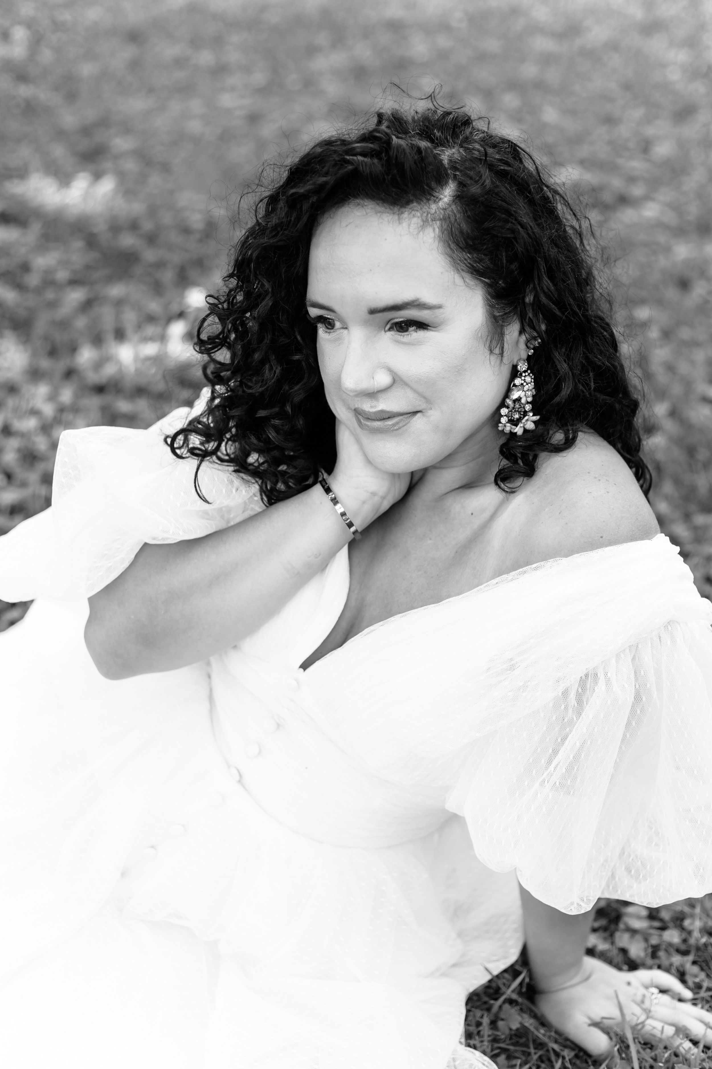 A sequence of black and white portraits showing a woman in a white dress with curly dark hair expressing different emotions.