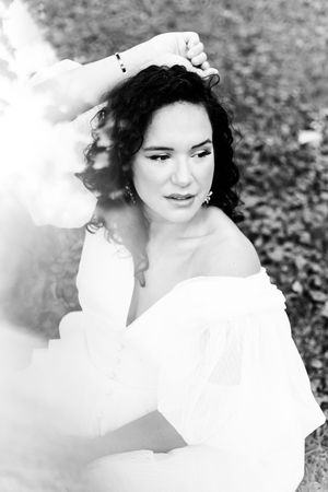 Black and white portrait series showing a figure in white clothing with dark curly hair against a soft blurred background.