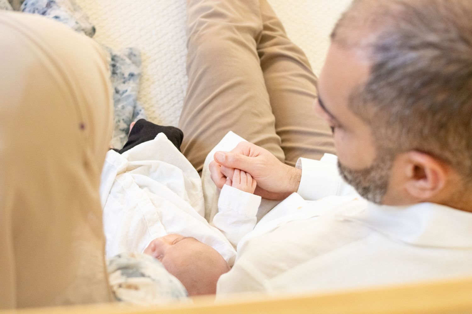 couple holding newborn baby at home photoshoot