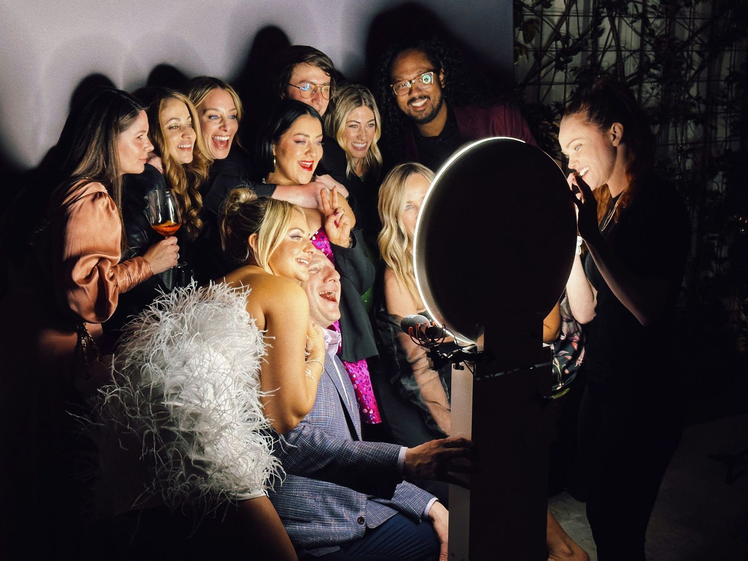 Group of friends pose together at a dimly lit party with dramatic lighting.
