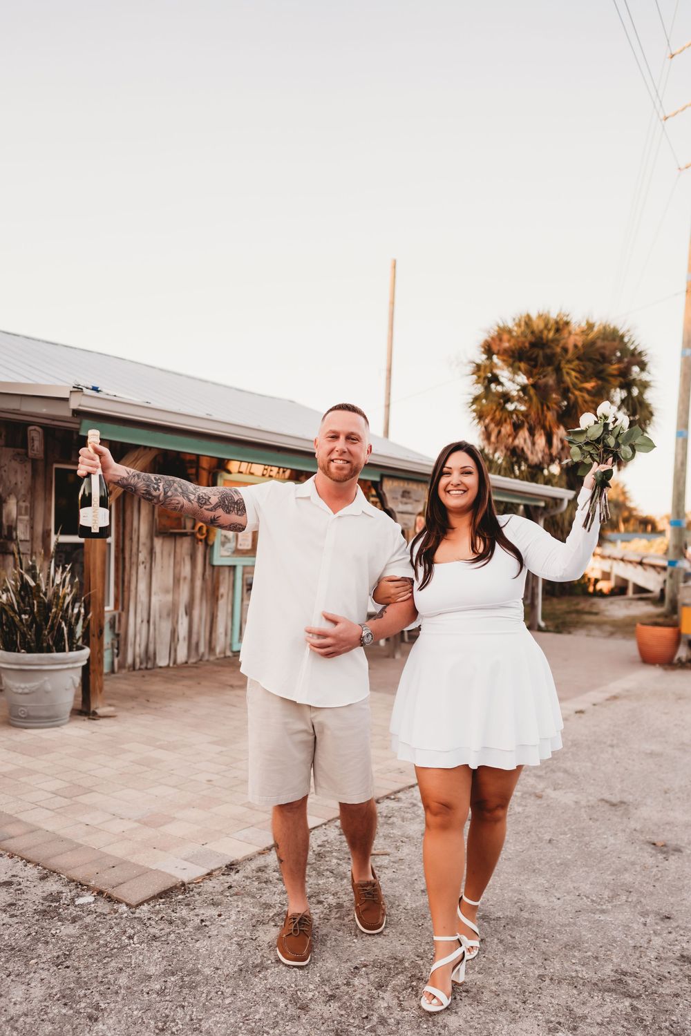 Playful engagement photos with champagne pop during golden hour in Aripeka Florida