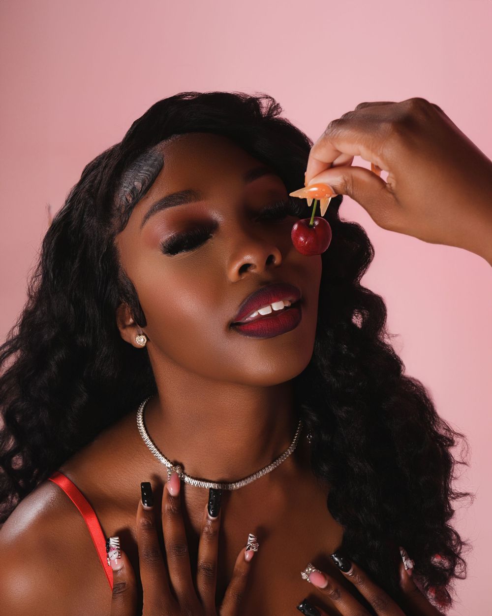 A beauty portrait series with red lips and glowing skin against a pink background.