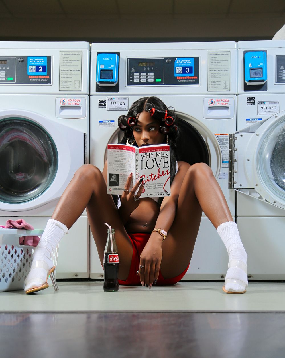 A sequence of artistic photos showing someone lying down in front of laundromat washing machines in white boots.