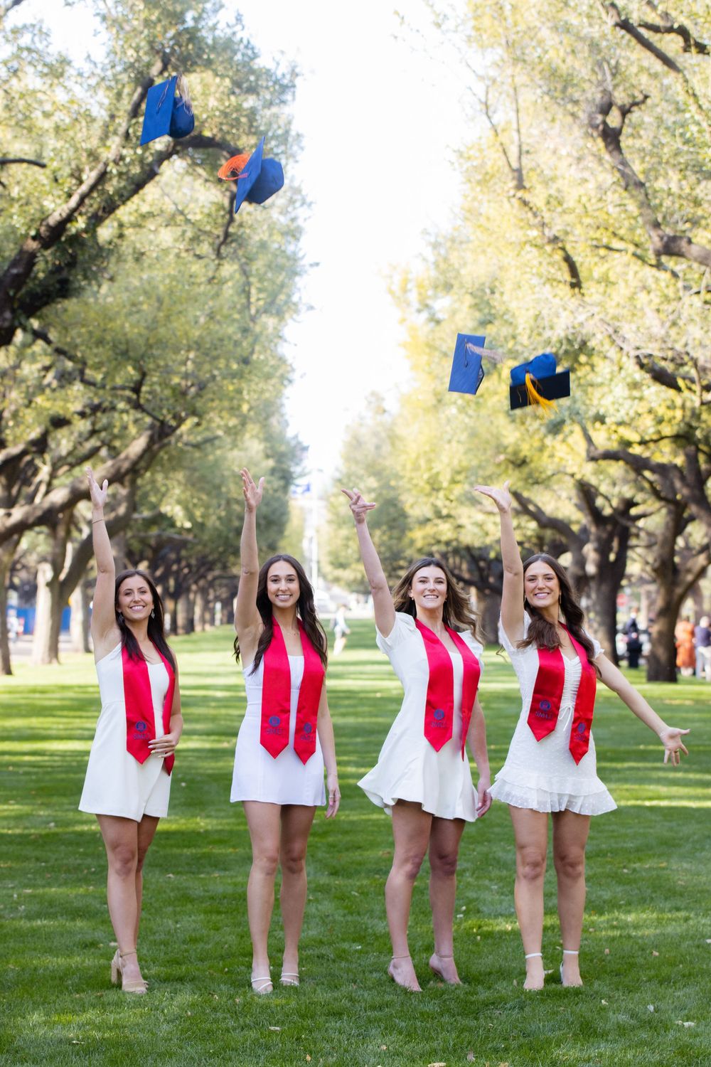 A sequence of photos showing a group in white dresses and red vests posing on a grassy lawn with trees in the background.