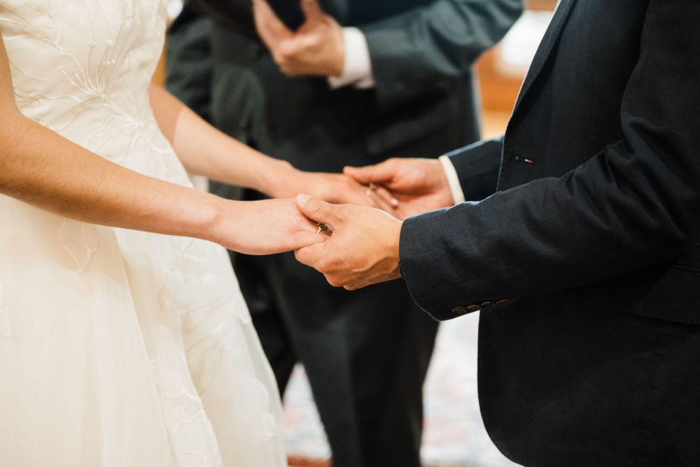 Close-up of wedding couple's hands during ring exchange ceremony.