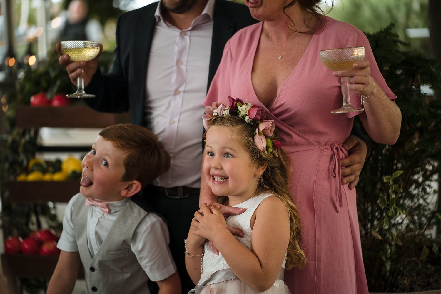Joyful children express excitement during a wedding reception in Halifax, Nova Scotia as adults hold champagne glasses in the background.