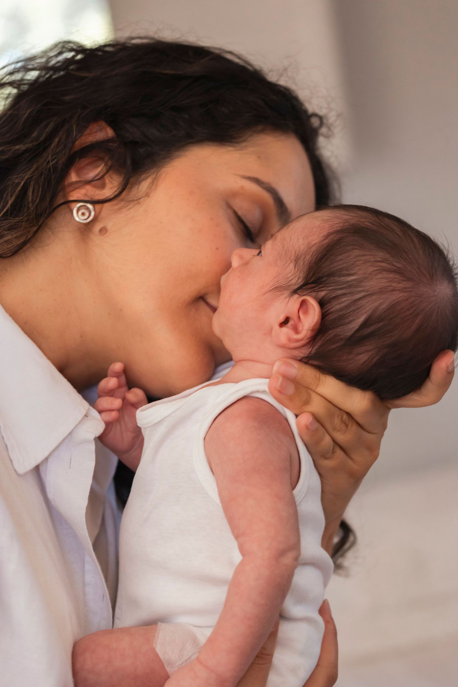 Newborn photography session. Emotional photograph showing gentle moments of connection and bonding.