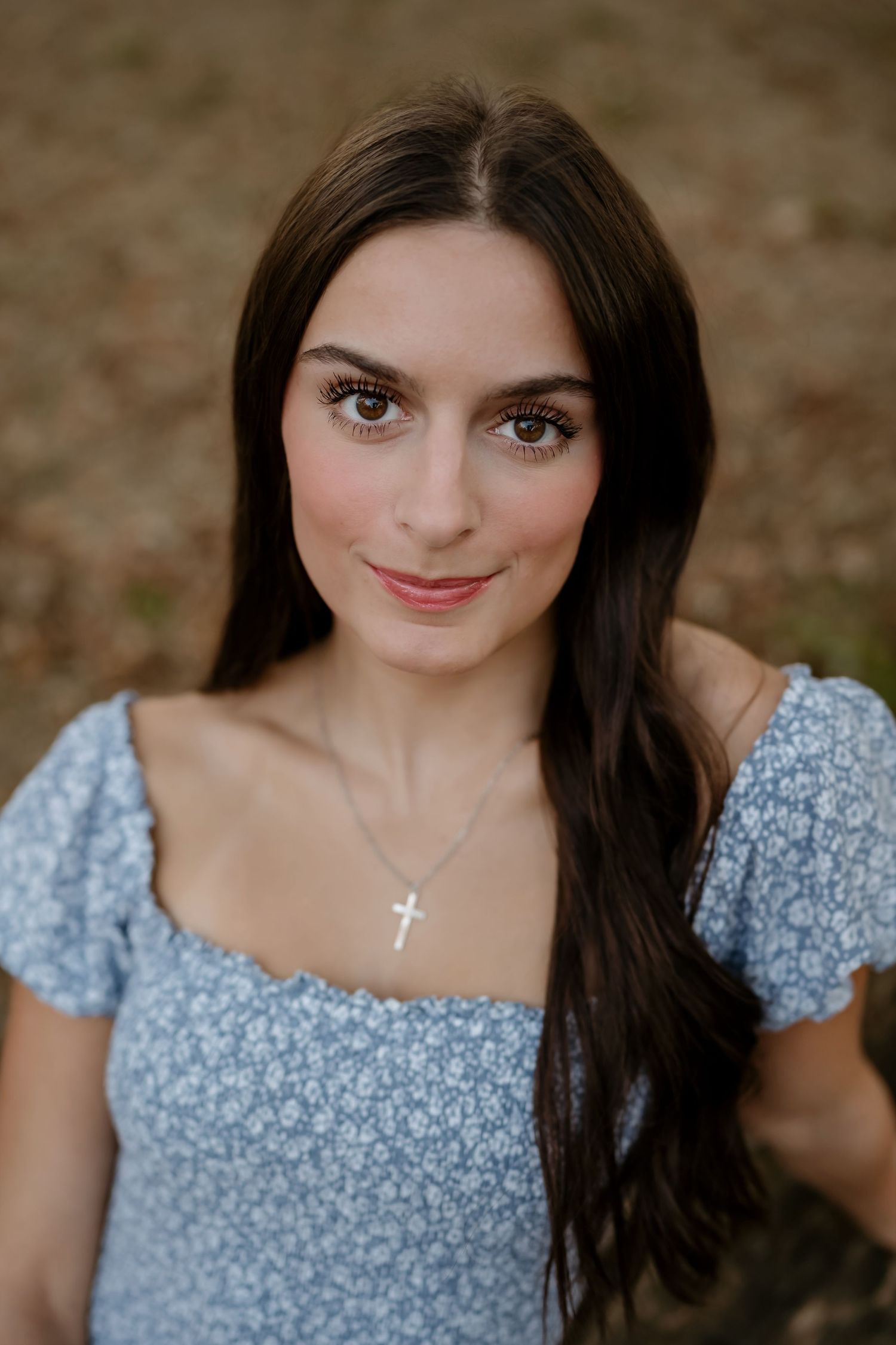 A series of portrait photos showing someone wearing a blue floral dress against a blurred natural background.