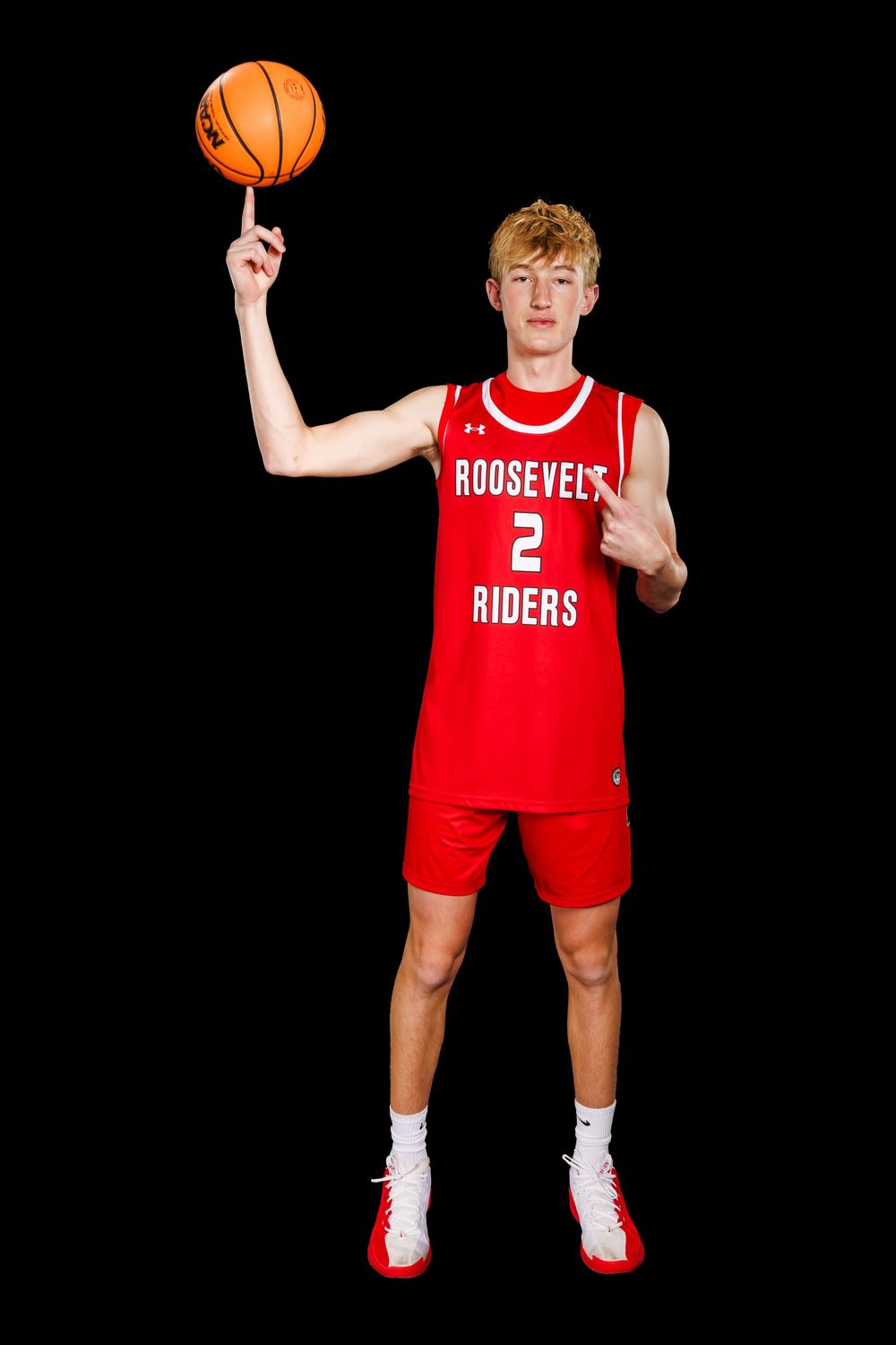 Basketball player in red Roosevelt jersey number 2 poses with basketball against dark backdrop.