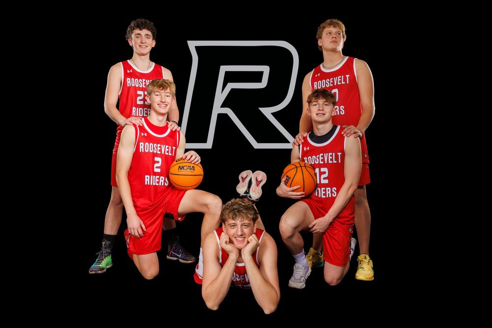 Group of Roosevelt basketball players pose together with team logo in red uniforms.