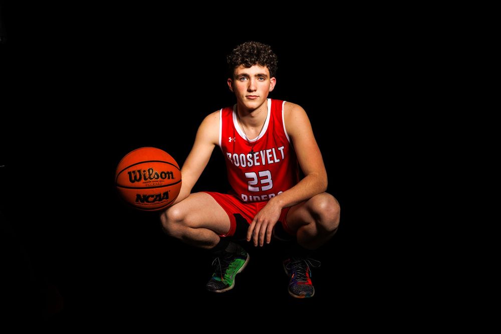 Player crouches with basketball wearing Roosevelt number 23 jersey.