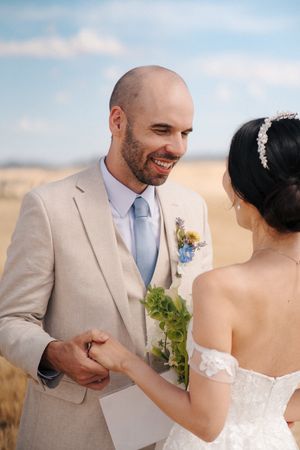 Wedding couple shares intimate moments in a rustic outdoor setting with soft natural lighting.