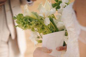 Elegant wedding table settings with white linens and fresh greenery decorations.