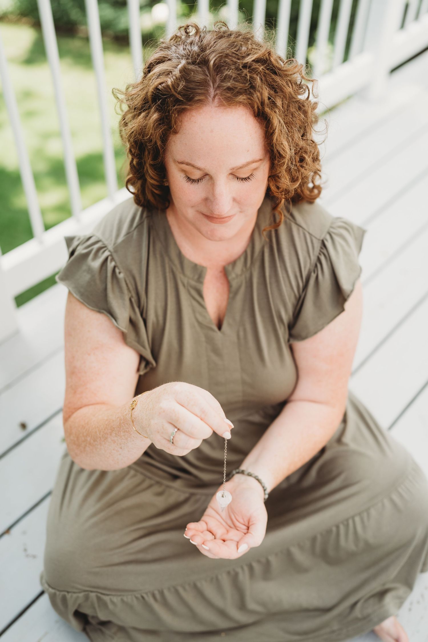Person in olive green shirt sitting on white porch examining something in their hand in a series of photos.