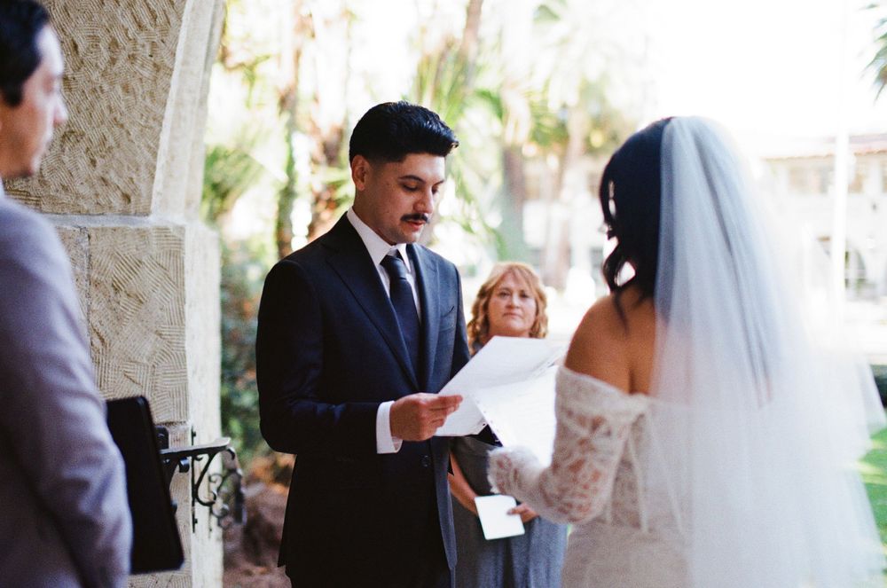 A 35mm film photo of a groom reciting emotional vows to his bride on their elopement day at the Santa Barbara County Courthouse
