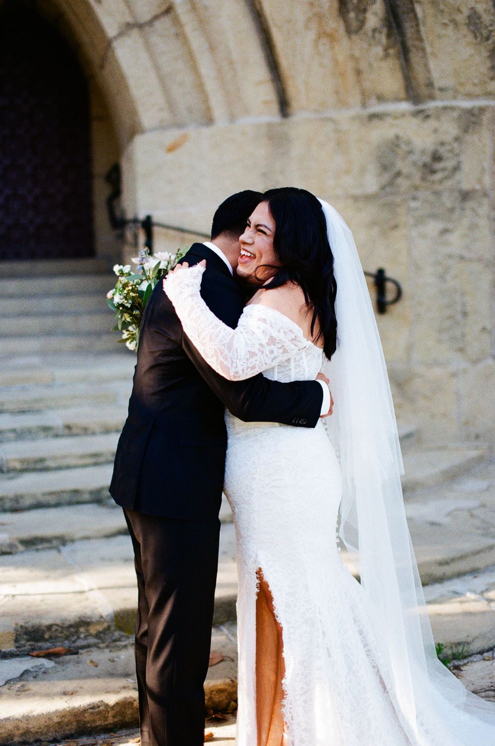 A bride and groom laugh and embrace at the Santa Barbara Courthouse captured on 35mm film by a Santa Barbara Wedding Photographer