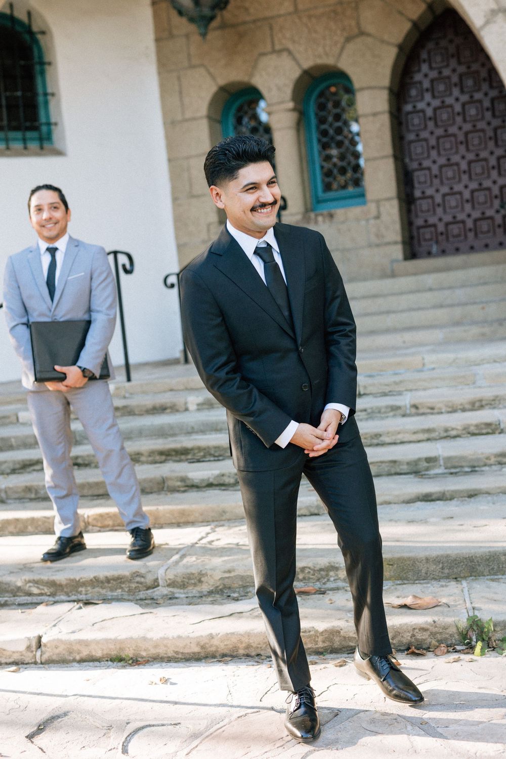 A groom waits for bride while eloping at the Santa Barbara Courthouse