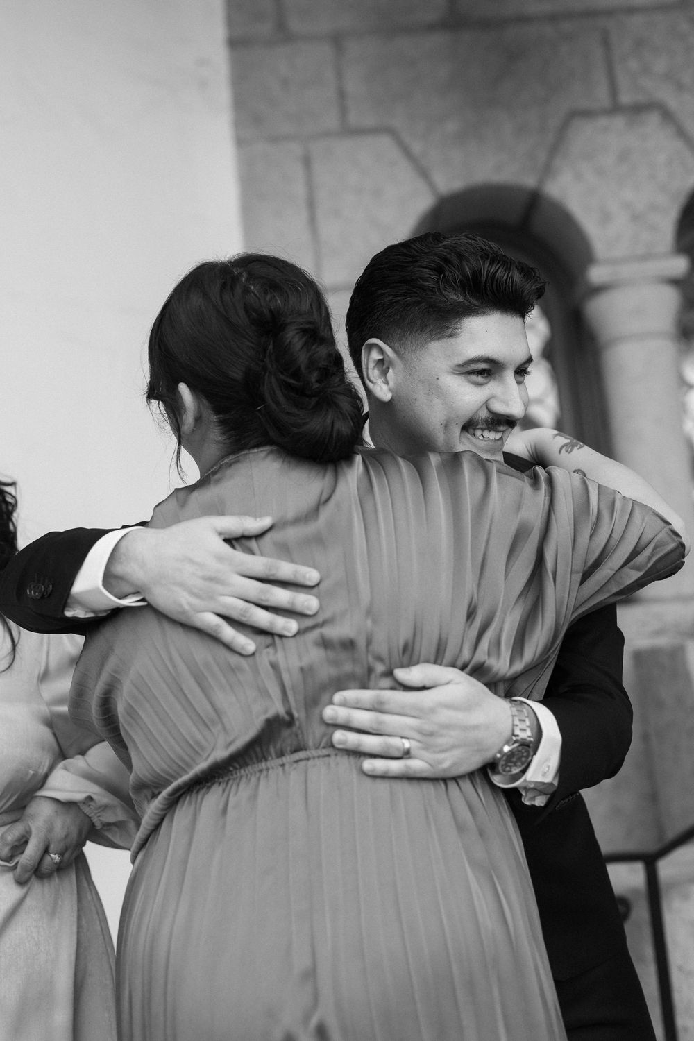 A groom hugs his mother in an emotional black and white photo captured by a Santa Barbara Courthouse photographer