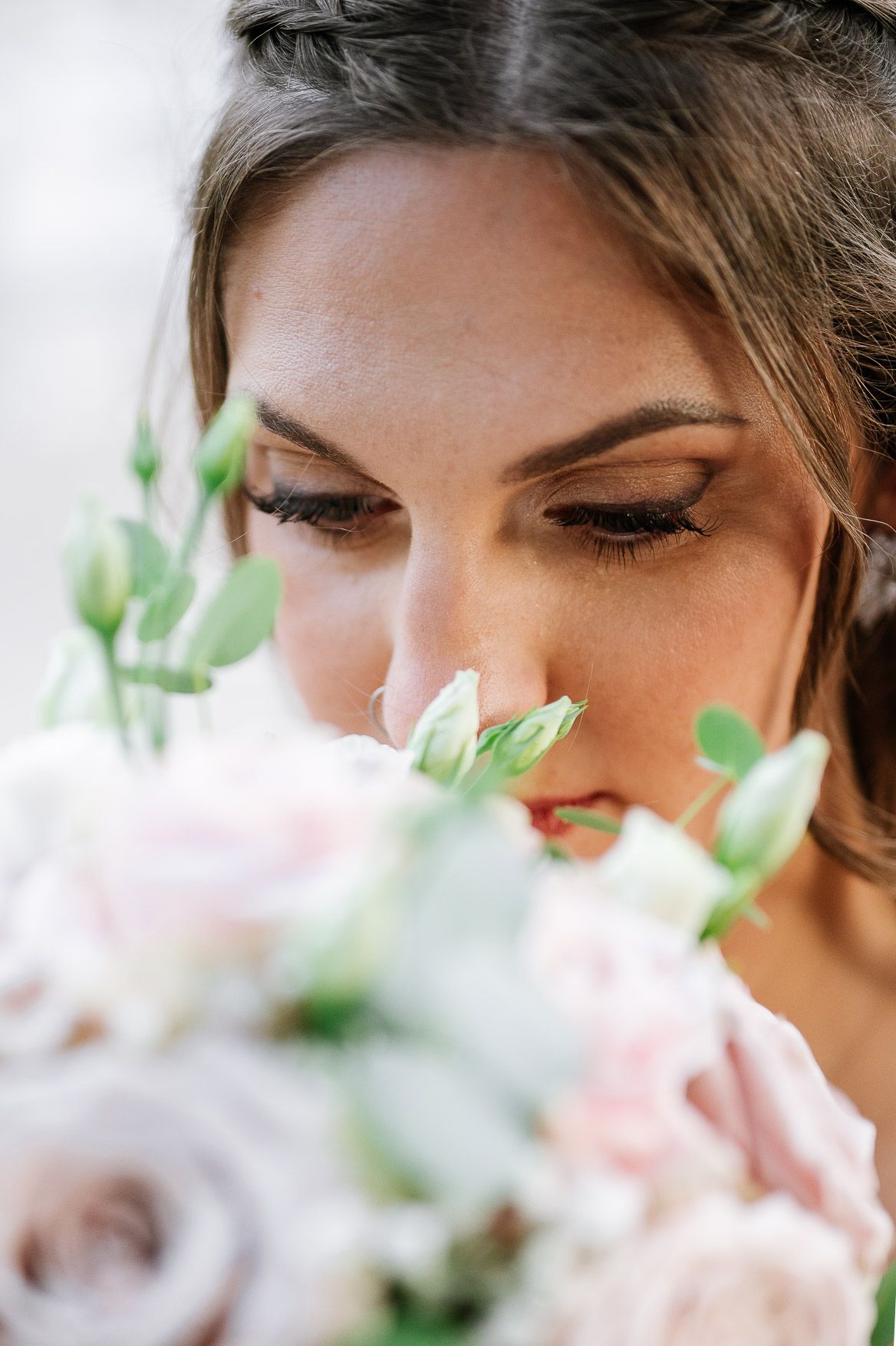 Close-up artistic shots of bridal makeup and eyelashes with soft pink floral elements in frame.