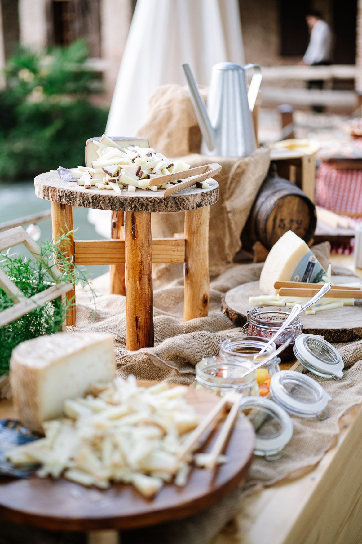 Rustic wedding reception table features artisanal cheese boards and wooden serving platters.