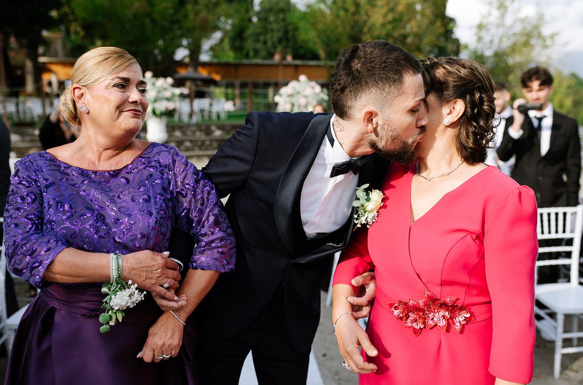 Wedding guests enjoying outdoor reception in formal attire.