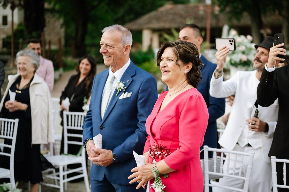 Wedding celebration with guests in formal attire enjoying outdoor reception.