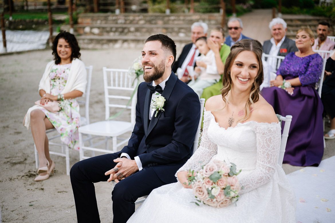 Outdoor wedding ceremony setup with white chairs and floral decorations.