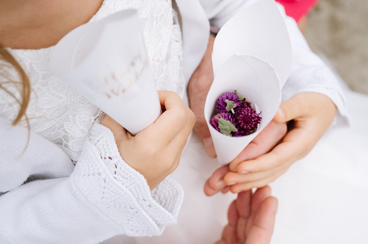 Close-up of hands holding delicate white lace and floral details.