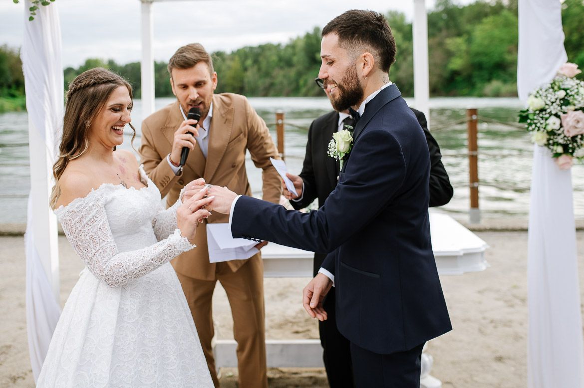 Emotional moments during waterfront wedding ceremony under white gazebo.
