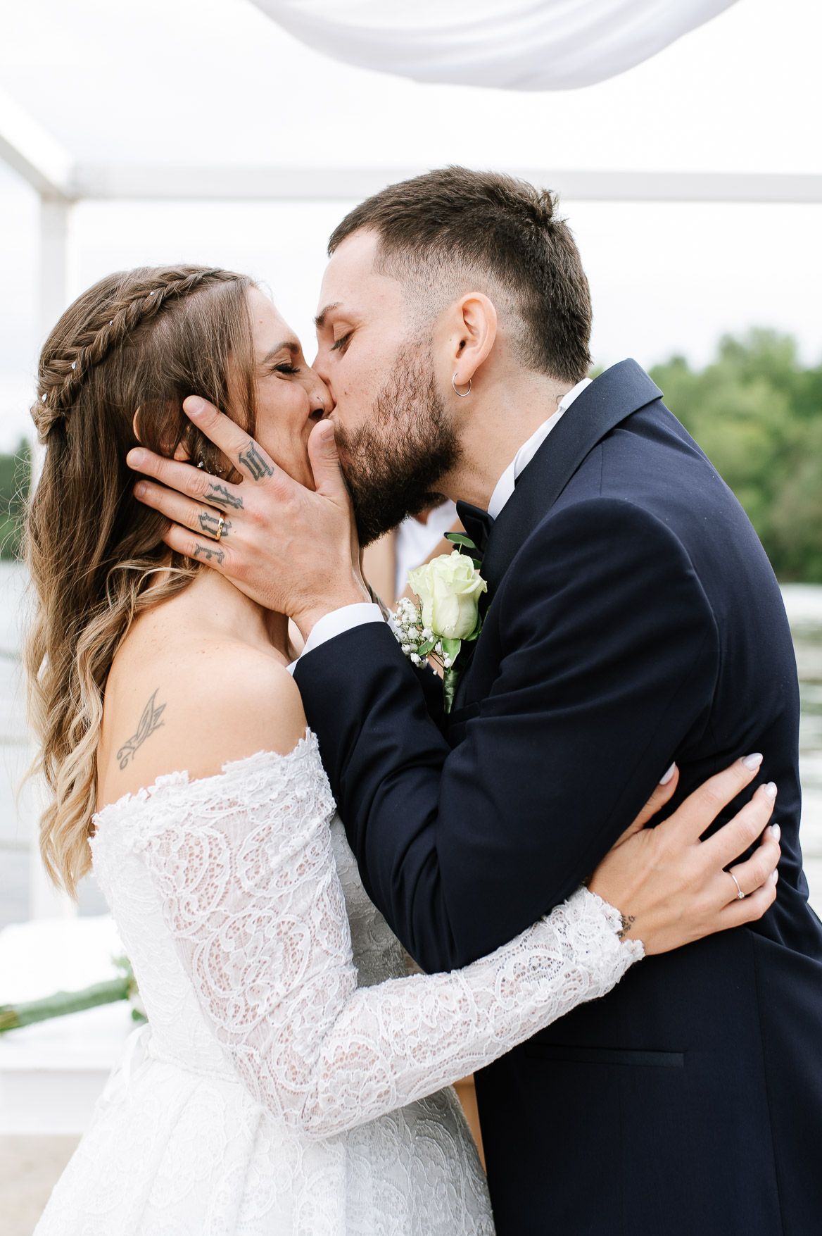 Romantic wedding couple sharing intimate moments during outdoor photoshoot.