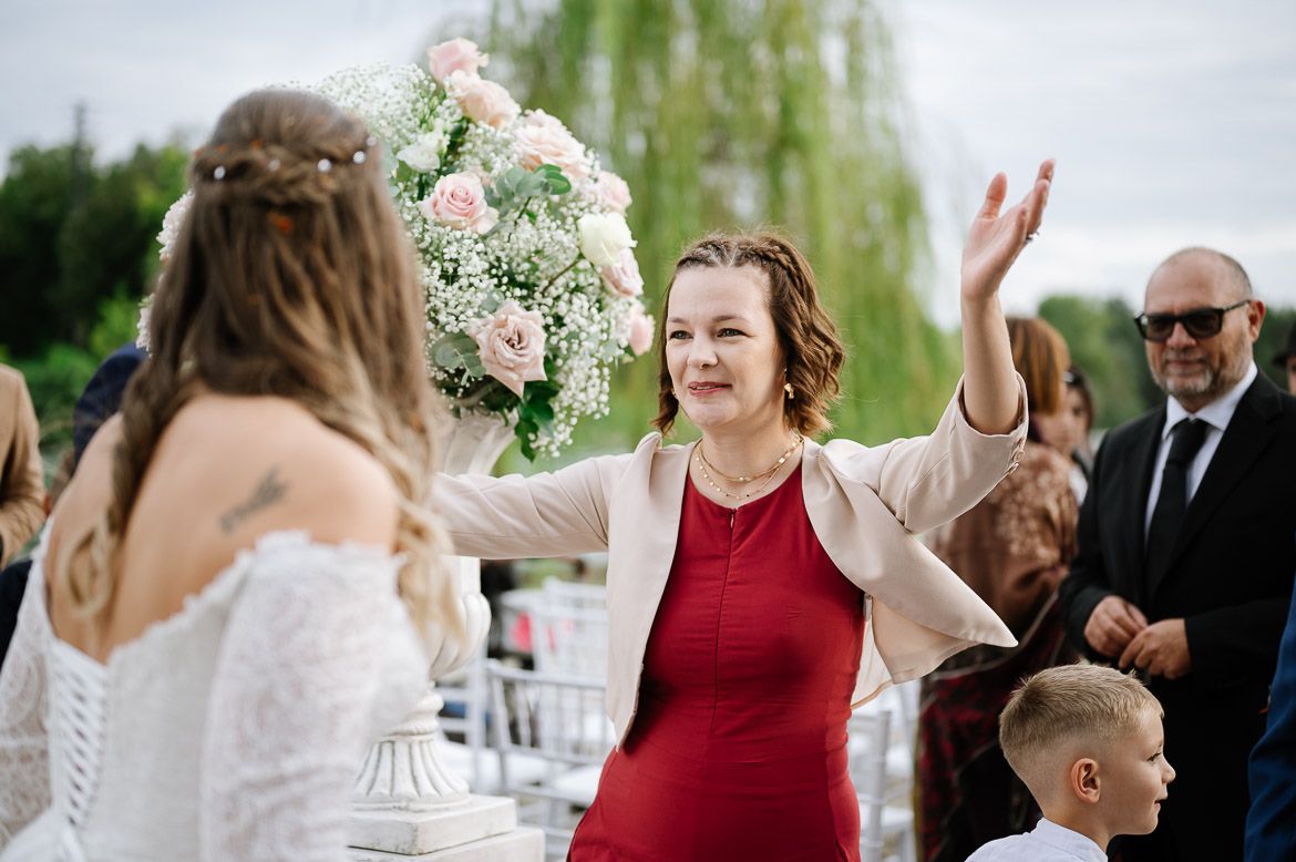 Wedding guests celebrate and dance together at an outdoor reception with white floral decorations.