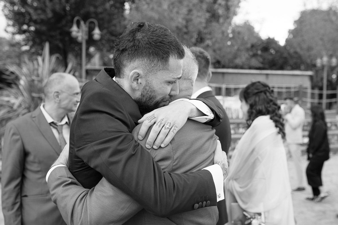 Black and white photo of emotional embraces during wedding celebration moments.