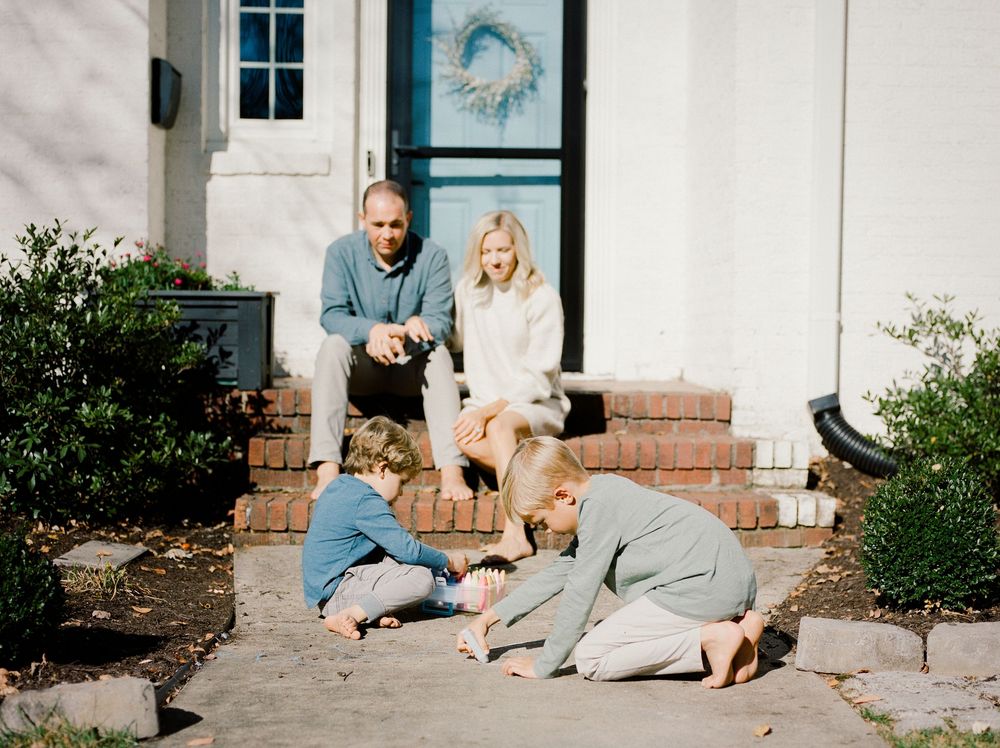 A series of progressive photos showing a family with their dog sitting on outdoor steps for a portrait session.
