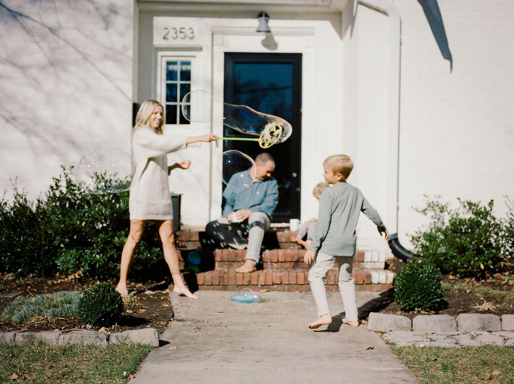 A sequence of playful moments captured outside a white house with house number 2353.