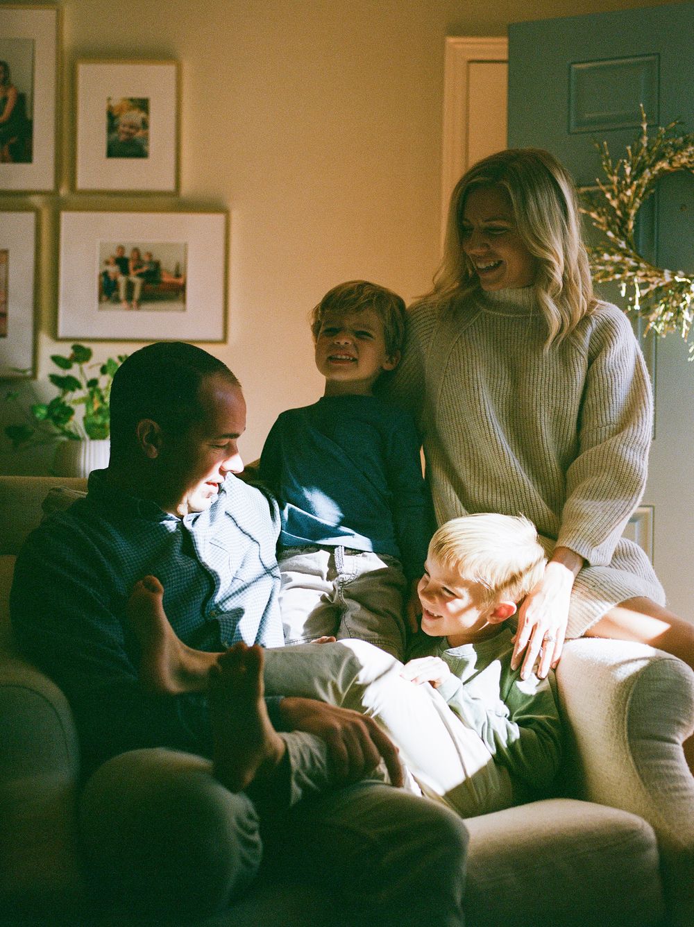 A series of candid family moments captured on a couch in warm, intimate lighting.