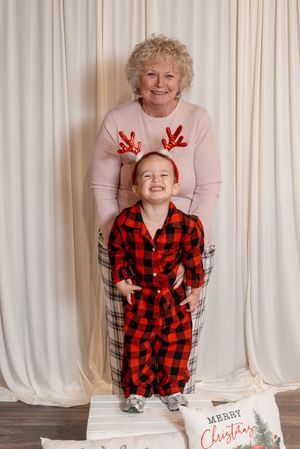 Holiday portrait session with child in buffalo plaid and decorative reindeer antlers.