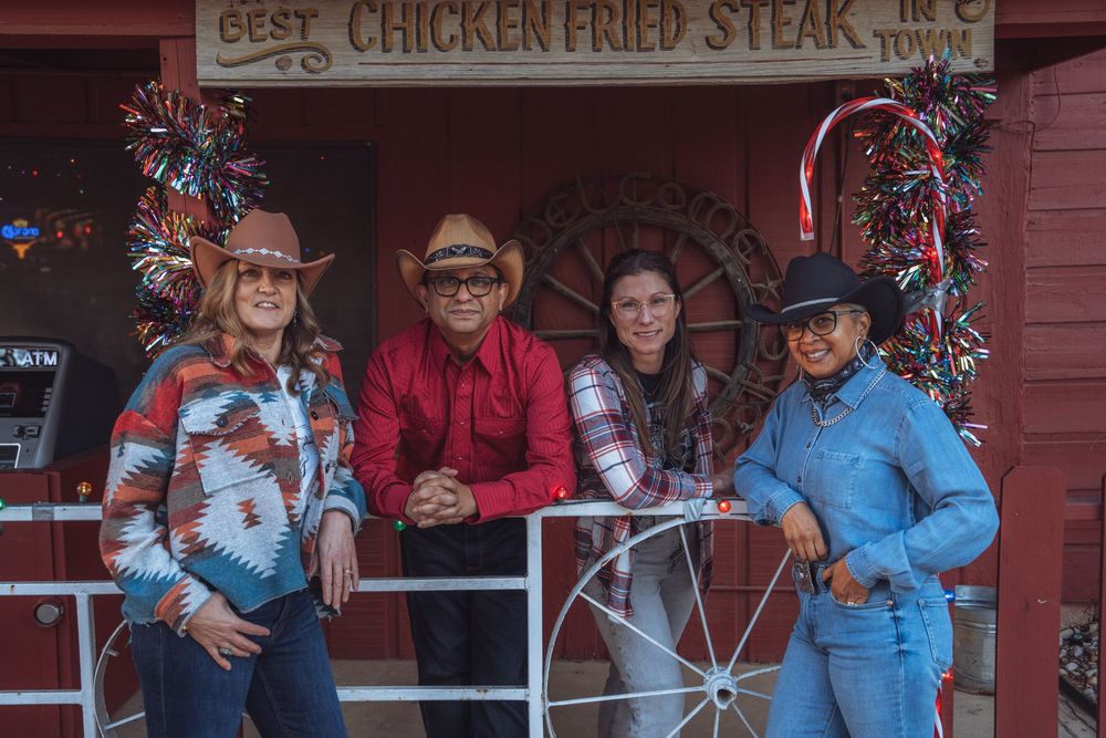 A rustic bar interior with a vintage 'Best Chicken Fried Steak' sign and holiday decorations.