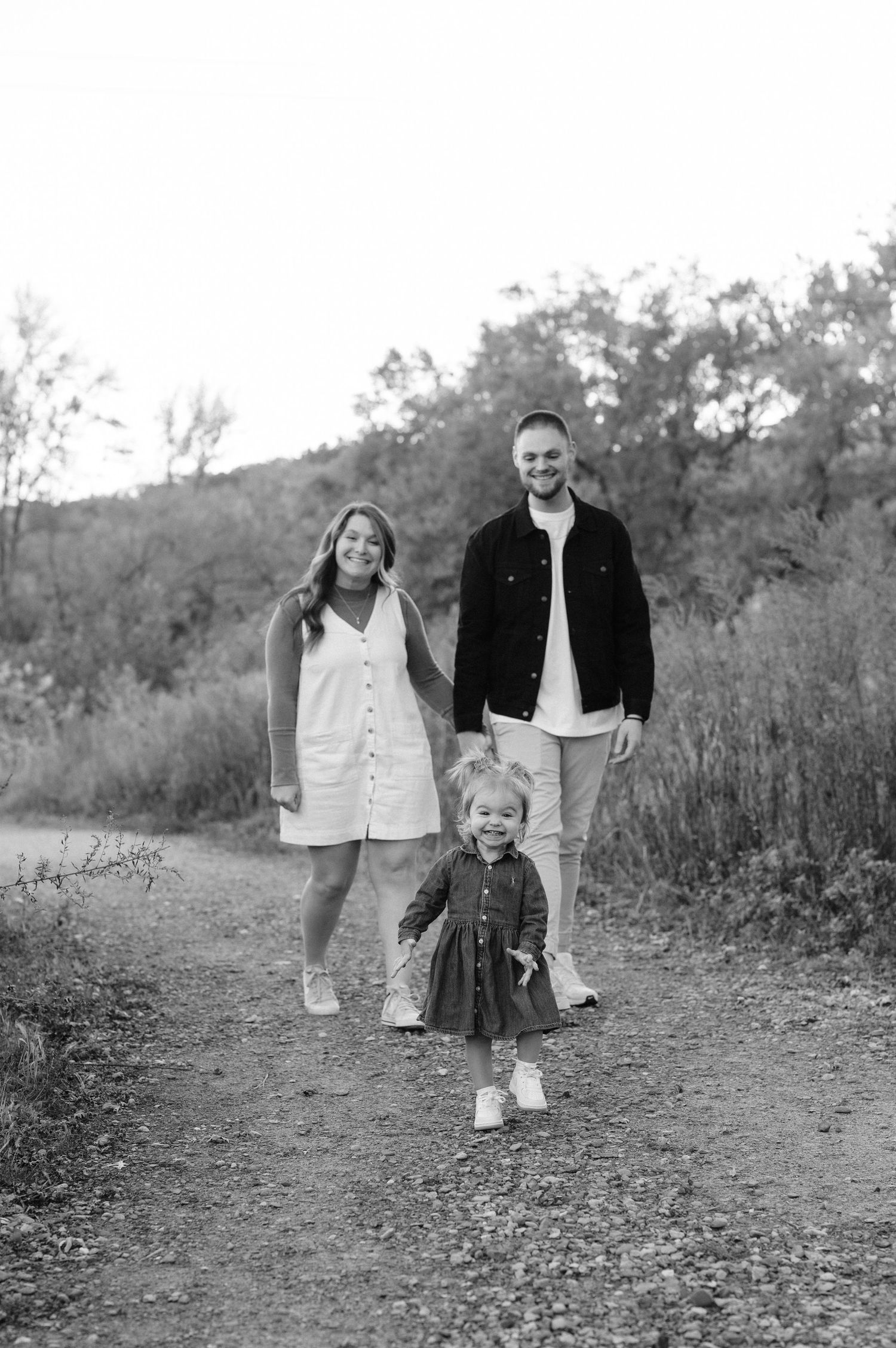 A couple shares playful and candid moments in a series of black and white outdoor photographs.