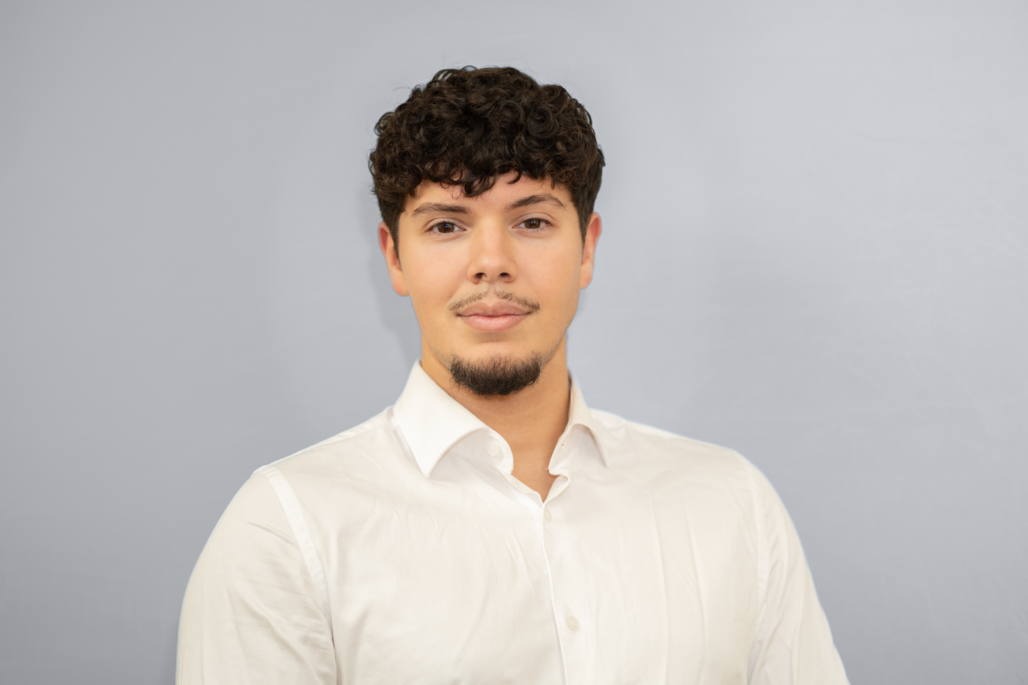 Portrett av ung mann i hvit skjorte mot grå bakgrunn, CV-foto og headshot av Prospectxmedia.