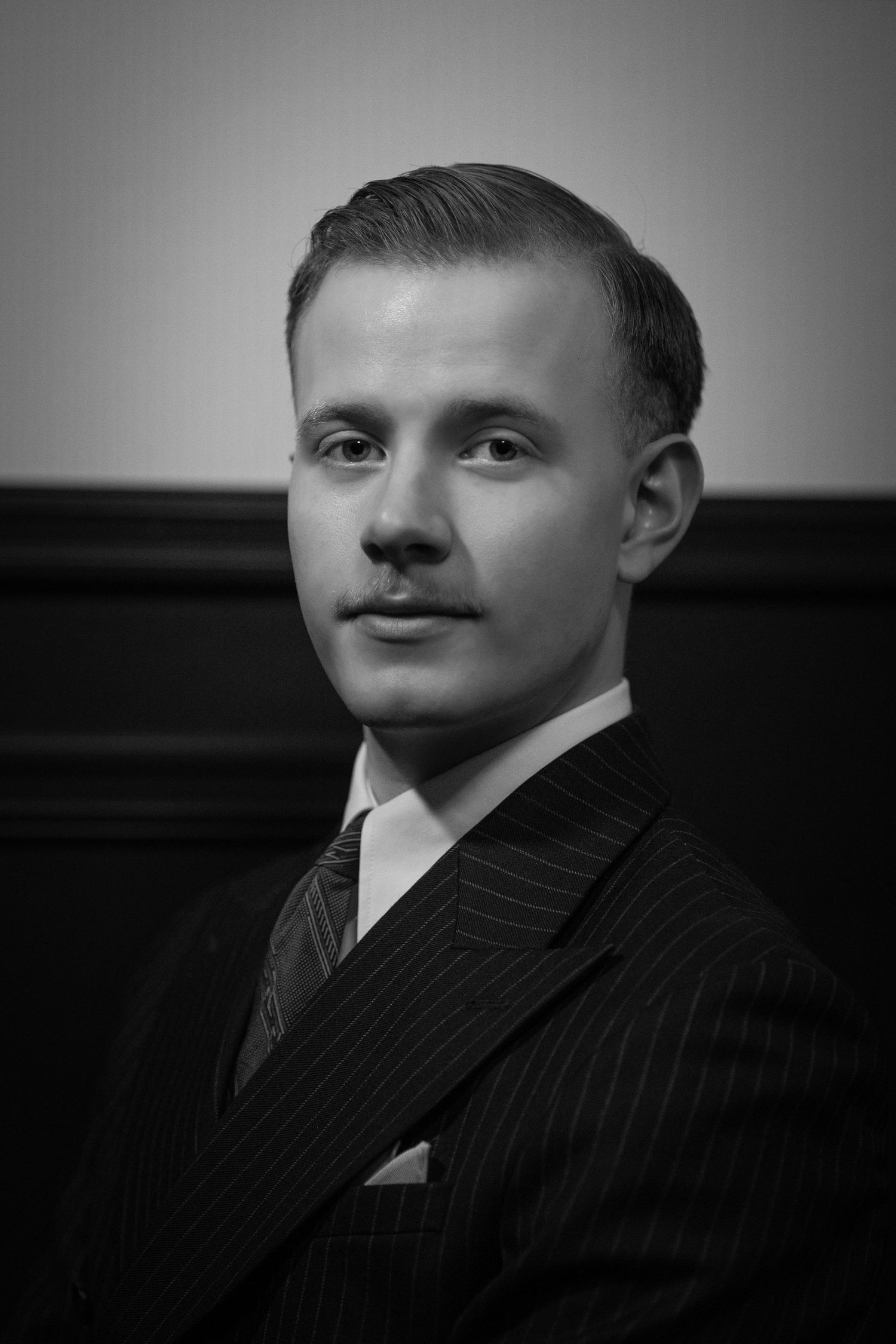 Dramatisk sort/hvitt portrett av mann i dress, kreativ portrettfotografering av Prospectxmedia.
