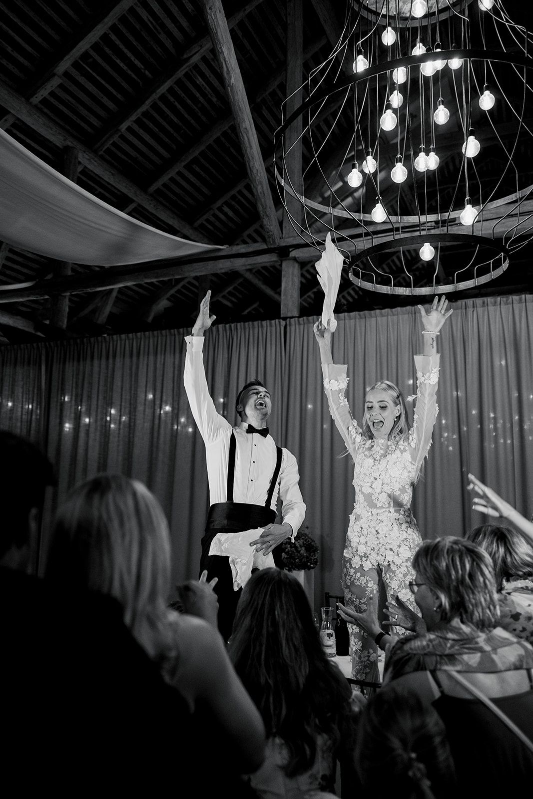 A sequence of black and white photos showing people dancing and celebrating with their arms raised at a wedding reception.
