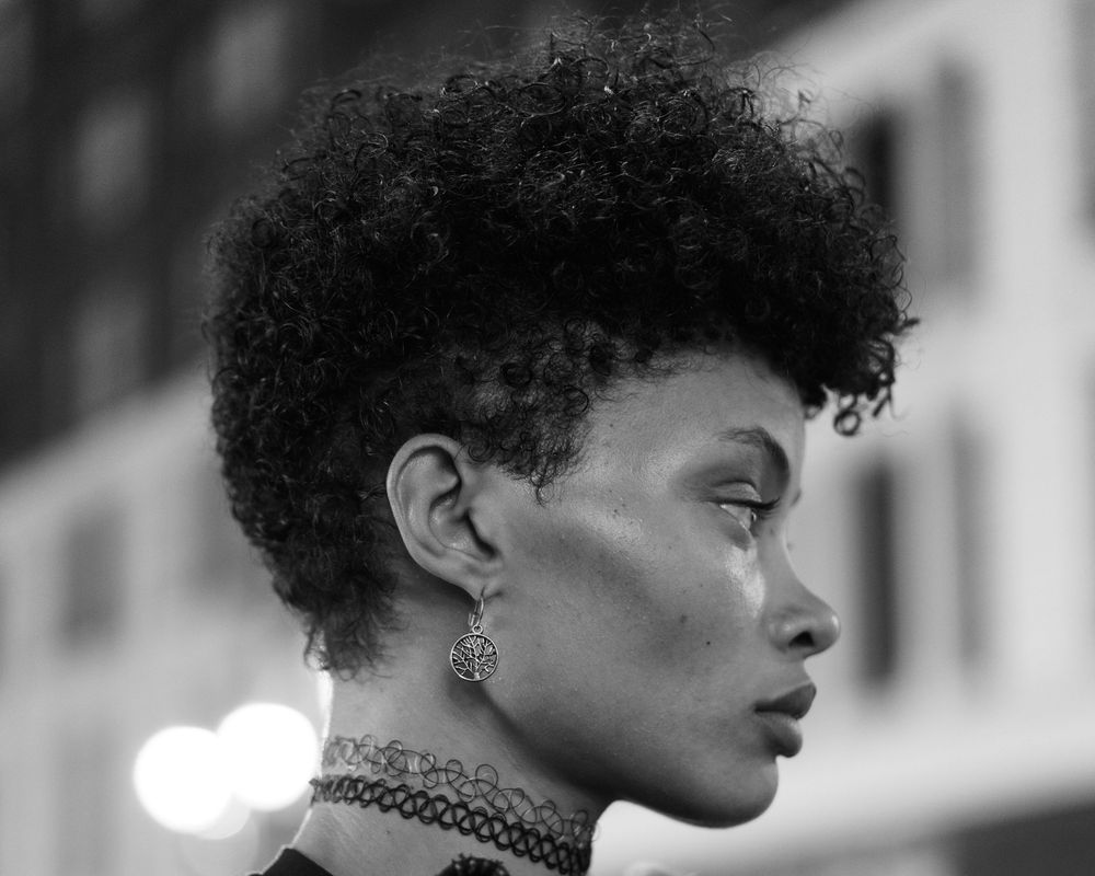 Dramatic black and white fashion portraits showcasing natural curly hair and choker necklace.