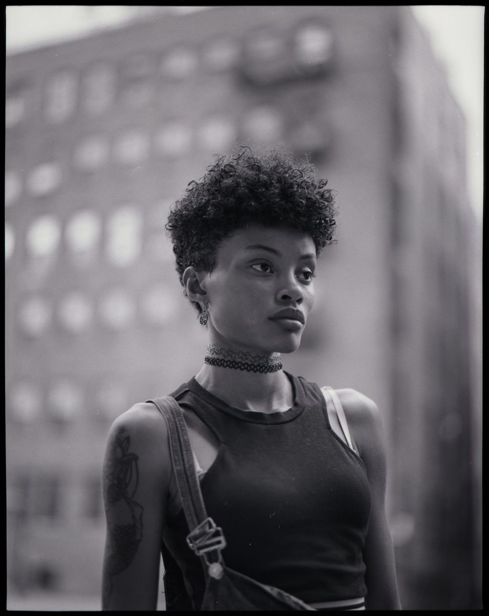 Artistic black and white portrait series showing profile angles in an urban setting.