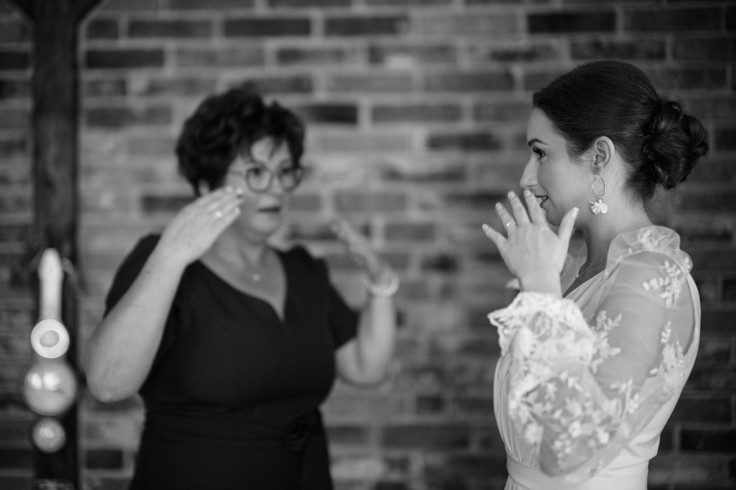 A black and white photo sequence showing joyful dance movements against a brick wall backdrop.